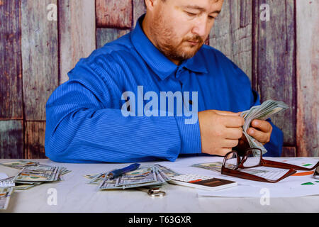 Bargeld in Händen Mann zählen Geld Dollar in der Menschen Hände ein Mann in Business Kleidung mit Stack von Dollar. Stockfoto