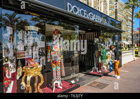 CANNES, Frankreich - April 2019: Person, die in das Fenster des Dolce&Gabbana Store auf der Strandpromenade von Cannes. Stockfoto