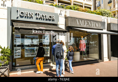 CANNES, Frankreich - April 2019: Leute stoppen im Fenster "ein Makler an der Strandpromenade von Cannes zu sehen. Stockfoto