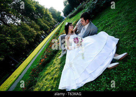09/07/2008 Moskau Russland/Bräutigam und Braut liegen auf Gras und einander in die Augen schauen Stockfoto