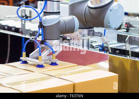 Der Roboterarm transfers Karton zu Fließband; close up Stockfoto