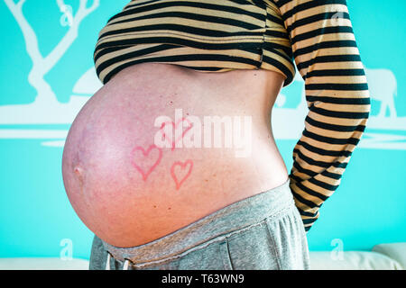 Junge schwangere Frau zeigte ihr schön Bauch mit Baum rot Valentinstag Liebe Herz mit Lippenstift lackiert gerundet Stockfoto