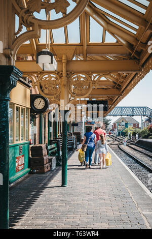 Sheringham, Großbritannien - 21 April, 2019: Familie gehen auf einem Bahnsteig von Sheringham Bahnhof an einem sonnigen Frühlingstag. Sheringham ist ein Englischer seasid Stockfoto