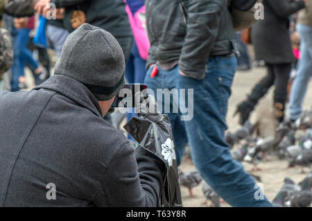 Das Fotografieren von Tauben auf dem Dam Platz in Amsterdam Die Niederlande 2019 Stockfoto