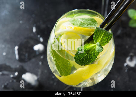 Mojito Cocktail oder Limonade mit Limette und Minze im Glas auf Schwarz. Close Up. Sommer erfrischendes Getränk. Platz für Text. Stockfoto