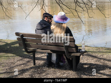 Paar sitzt auf der Bank im Park, mit Blick auf den Lake Victoria. Stratford, Ontario. Stockfoto