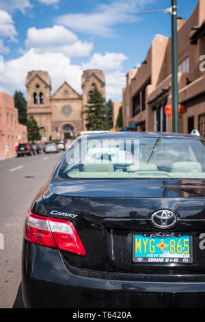 Die Platte von New Mexico, USA auf einem geparkten Auto in der Innenstadt von Santa Fe. Hl. Franz Dom im Hintergrund Stockfoto