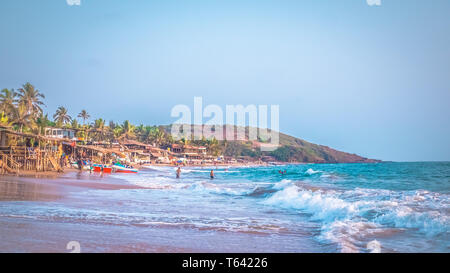 Schöne Anjuna Beach im Norden von Goa, Indien. Beliebte strand ferien Destination in Goa mit blau Arabische Meer Wellen, Felsen, und typische Strand Stockfoto