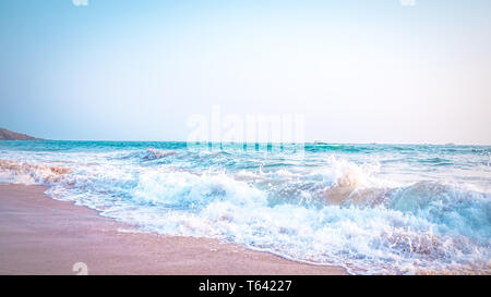 Schöne Anjuna Beach im Norden von Goa, Indien. Beliebte strand ferien Destination in Goa mit blau Arabische Meer Wellen, Felsen, und typische Strand Stockfoto