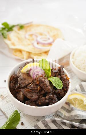 Rinderleber frittieren oder Braten serviert mit Reis und Roti, selektiver Fokus Stockfoto