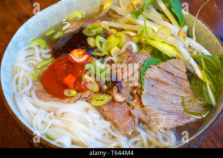 Pho Bo - Lecker Rindfleisch und Huhn Nudeln Suppen asiatische Küche berühmte vietnamesische Küche mit Rinderbrühe Frühlingszwiebel hoisin Sauce Sojasauce chilly Kraut Stockfoto