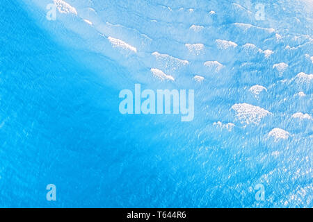 Die hellen, blauen tropischen Meer mit Wellen Luftaufnahme. Natürliche Textur und Hintergrund Stockfoto