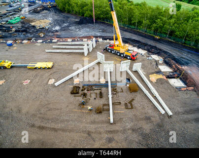 Luftaufnahme von riesigen Kran Installation von riesigen Stahlbeton Stapel auf der Baustelle. Stockfoto