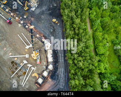 Luftaufnahme von riesigen Kran Installation von riesigen Stahlbeton Stapel auf der Baustelle. Stockfoto