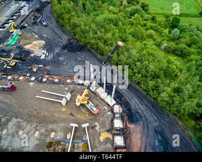 Luftaufnahme von riesigen Kran Installation von riesigen Stahlbeton Stapel auf der Baustelle. Stockfoto