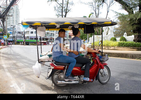 Phuket, Thailand, 20. Februar 2018: Straßenverkäufer von exotischen Essen fahren mit dem Moped. Stockfoto