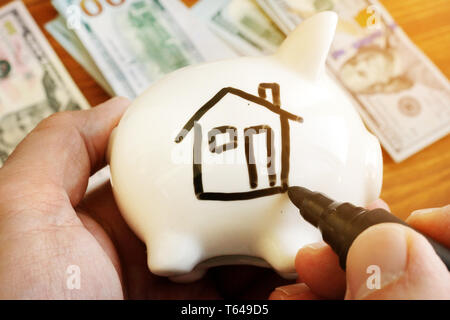 Sparen Sie Geld ein Haus kaufen. Sparschwein mit Home auf der Seite. Stockfoto