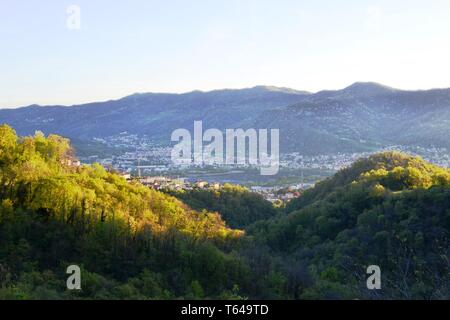 Schöner Panoramablick von der Straße auf den Wald auf hohen Bergen zu Erve, Calolziocorte und Garlate See, Rossino Burg in frühen Abend im Frühling. Stockfoto