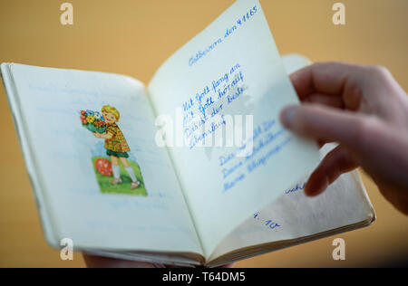 Oldenburg, Deutschland. 11 Apr, 2019. Stefan Walter, wissenschaftlicher Mitarbeiter am Institut für Pädagogik an der Carl-von-Ossietzky-Universität Oldenburg, schaut sich ein Poesie Album. Walter hat recherchiert und seine Dissertation über Poesie Alben geschrieben. Credit: mohssen Assanimoghaddam/dpa/Alamy leben Nachrichten Stockfoto