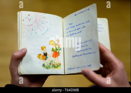 Oldenburg, Deutschland. 11 Apr, 2019. Stefan Walter, wissenschaftlicher Mitarbeiter am Institut für Pädagogik an der Carl-von-Ossietzky-Universität Oldenburg, schaut sich ein Poesie Album. Walter hat recherchiert und seine Dissertation über Poesie Alben geschrieben. Credit: mohssen Assanimoghaddam/dpa/Alamy leben Nachrichten Stockfoto