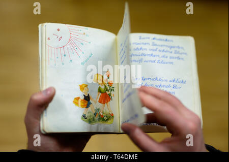 Oldenburg, Deutschland. 11 Apr, 2019. Stefan Walter, wissenschaftlicher Mitarbeiter am Institut für Pädagogik an der Carl-von-Ossietzky-Universität Oldenburg, schaut sich ein Poesie Album. Walter hat recherchiert und seine Dissertation über Poesie Alben geschrieben. Credit: mohssen Assanimoghaddam/dpa/Alamy leben Nachrichten Stockfoto