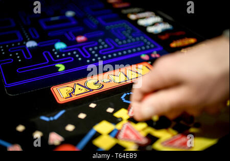 Berlin, Deutschland. 10 Apr, 2019. Ein junger Mann spielt "Pac Man" am Automaten in der Ausstellung "90er Jahre Berlin" an der Alten Münze. (Dpa Skateboards, Bauchfrei, Nirvana - Die 90er sind zurück) Credit: Britta Pedersen/dpa-Zentralbild/dpa/Alamy leben Nachrichten Stockfoto