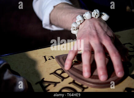 Berlin, Deutschland. 24 Apr, 2019. Der Schauspieler Alex van Ric (als Medium) mit einem Ouija Brett an der Berliner Dungeon. Die show éance - Haben Sie Ihr das Gefühl auch?" geht es um ein Medium, das versucht, den Geist einer Frau während einer Nekromantie zu zaubern. Quelle: Britta Pedersen/dpa-Zentralbild/ZB/dpa/Alamy leben Nachrichten Stockfoto