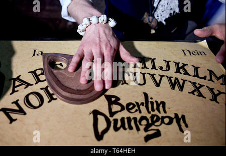 Berlin, Deutschland. 24 Apr, 2019. Der Schauspieler Alex van Ric (als Medium) mit einem Ouija Brett an der Berliner Dungeon. Die show éance - Haben Sie Ihr das Gefühl auch?" geht es um ein Medium, das versucht, den Geist einer Frau während einer Nekromantie zu zaubern. Quelle: Britta Pedersen/dpa-Zentralbild/ZB/dpa/Alamy leben Nachrichten Stockfoto