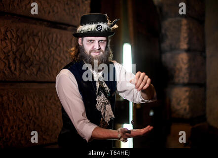 Berlin, Deutschland. 24 Apr, 2019. Der Schauspieler Alex van Ric (als Medium) hält ein Pendel in der Hand in der Berliner Dungeon. Die show éance - Haben Sie Ihr das Gefühl auch?" geht es um ein Medium, das versucht, den Geist einer Frau während einer Nekromantie zu zaubern. Quelle: Britta Pedersen/dpa-Zentralbild/ZB/dpa/Alamy leben Nachrichten Stockfoto