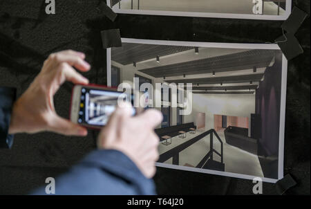 Berlin, Deutschland. 29 Apr, 2019. Bei einer Besichtigung der Baustelle des Zweiten feste Spielstätte des Berliner Ensembles, ein Mann Fotografien die Designs der Zukunft Foyer an eine Wand geklebt. Das Gebäude des neuen Theaters wird im Innenhof des Theaters gebaut werden. Foto: Jens Kalaene/dpa/Alamy leben Nachrichten Stockfoto