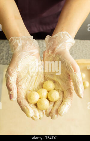 Der Prozess der Herstellung handgefertigte Pralinen. Runde Schokolade Süßigkeiten in den Händen des Konditors. Selektive konzentrieren. Stockfoto