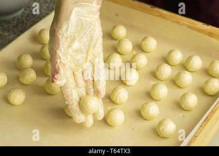 Der Prozess der Herstellung handgefertigte Pralinen. Runde Schokolade Süßigkeiten in den Händen des Konditors. Selektive konzentrieren. Stockfoto