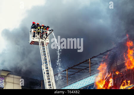 Feuerwehrmänner ein großes Feuer löschen Stockfoto