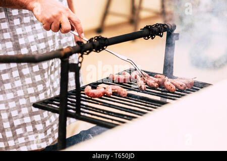 Nahaufnahme des Menschen Hände kochen frisches Fleisch auf einem alten Stil Holz und Feuer Grill BBQ Grill - home Feier für Leute, die gerne essen und mit frie genießen Stockfoto