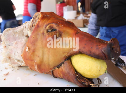 Schweinebraten mit einer großen Reife Zitrone in den Mund während eines Festivals party Stockfoto