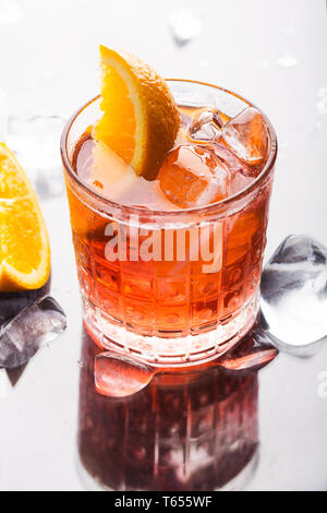 Frische rote farbenfrohen alkoholfreien Cocktail Aperol Spritz mit Orange und Eis im Glas auf grauem Hintergrund Stockfoto