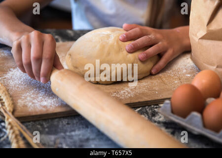 Kneten Sie den Teig mit den Zutaten auf dunklem Hintergrund Stockfoto