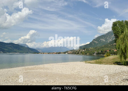 Schönen Sommer Panoramablick vom Kieselstrand von Abbadia Lariana an den Comer See und Mandello del Lario Stadt in einem sonnigen, heissen Tag. Stockfoto