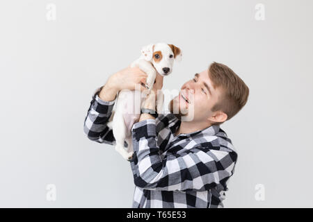 Menschen- und PET-Konzept - Nahaufnahme Portrait von Jack Russell Terrier Welpen sitzen auf die Hände des Menschen Stockfoto
