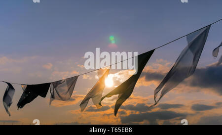 Satin Fahnen schwenkten im Wind bei Sonnenuntergang Stockfoto