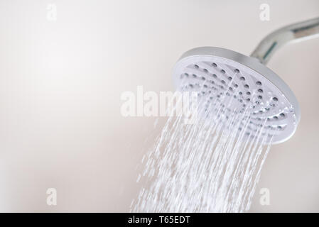 Nahaufnahme von einem Duschkopf mit fließendem Wasser Bewegung. Konzept der Hygiene, Gesundheit und Wasser sparen Stockfoto