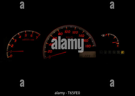 Das Armaturenbrett des Autos ist leuchtend weiß mit orangefarbenen Pfeilen in der Nacht mit einem Tachometer, Drehzahlmesser und andere Werkzeuge, um den Zustand des v zu überwachen Stockfoto