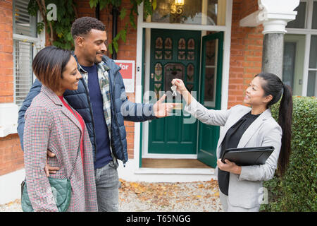 Immobilienmakler, Haus Tasten Paar außerhalb neues Haus Stockfoto