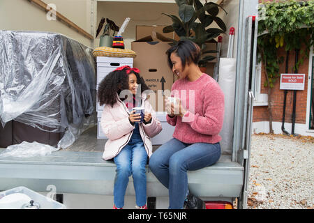 Mutter und Tochter Tee trinken an der Rückseite des Moving van Stockfoto