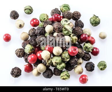 Schwarz, Weiß, Grün und rote Pfefferkörner auf weißem Hintergrund. Stockfoto
