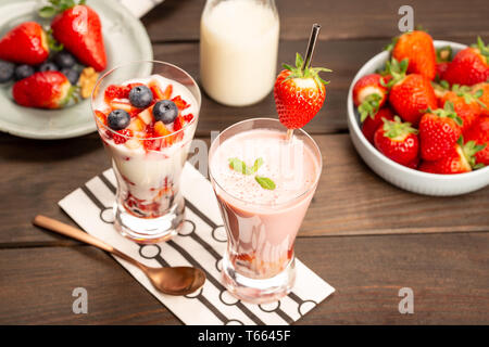 Gesunde Erdbeer Dessert. Verschiedene Smoothies im Glas auf rustikalem Holz Stockfoto