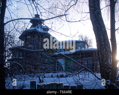 Alte hölzerne Haus hinter dem Zaun im Winter, Russland Stockfoto