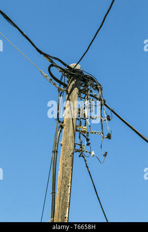 alte hölzerne Stromleitung, isoliert auf blauen Himmel Stockfoto