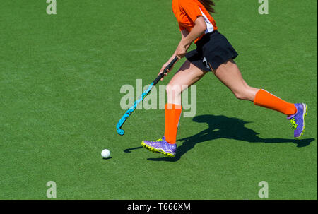 Jungen Hockeyspieler Frau mit Ball im Angriff spielen Hockey Game Stockfoto