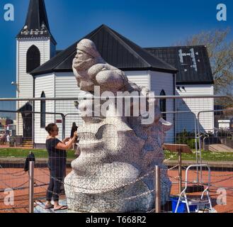 Scott Antarktis Memorial wird im Jahr 2018 mit der Norwegischen Kirche im Hintergrund, Cardiff Bay, Cardiff, Wales, Vereinigtes Königreich repariert Stockfoto